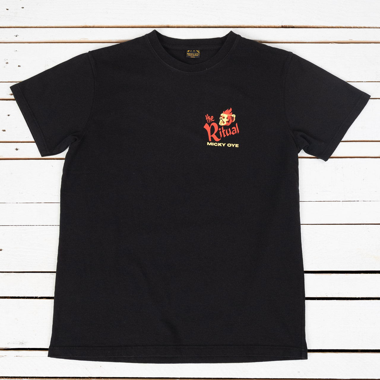 Micky Oye T-Shirt in Schwarz mit Print The Ritual auf der Brust, Ansicht von vorne, flach liegend auf weißem Untergrund