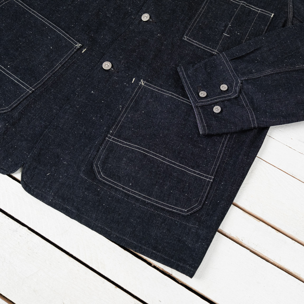Old Joe Brand Hampton Chore Jacket Indigo, Detailansicht der Ärmelmanschette auf einer Tasche liegend