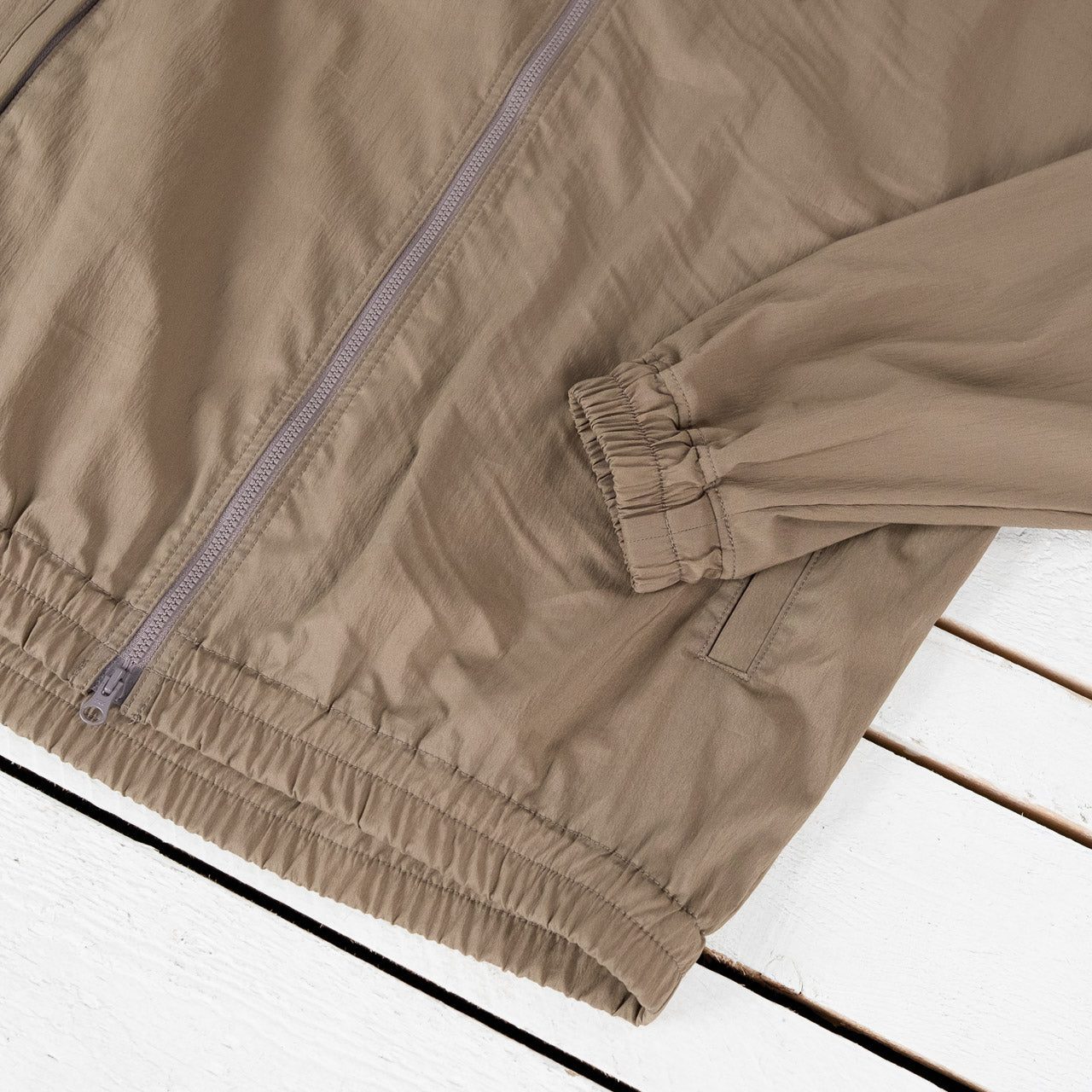 Jackman Crepe Parka Jacke mit Kapuze in Sepia, Detailansicht des Reißverschlusses und des Ärmelsaums, flach liegend